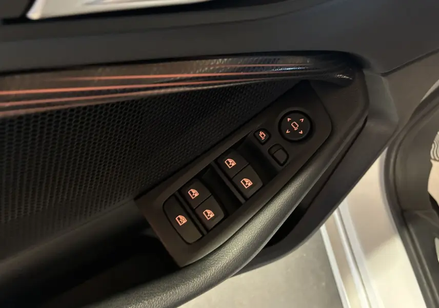 Gros plan sur les commandes électriques des vitres et rétroviseurs côté conducteur de la BMW Série 1 blanche, finition Edition Sport.