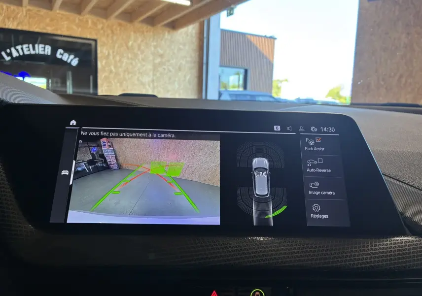 Écran multimédia de la BMW Série 1 118i Edition Sport 2023 montrant la caméra de recul avec guidage et assistance au stationnement.