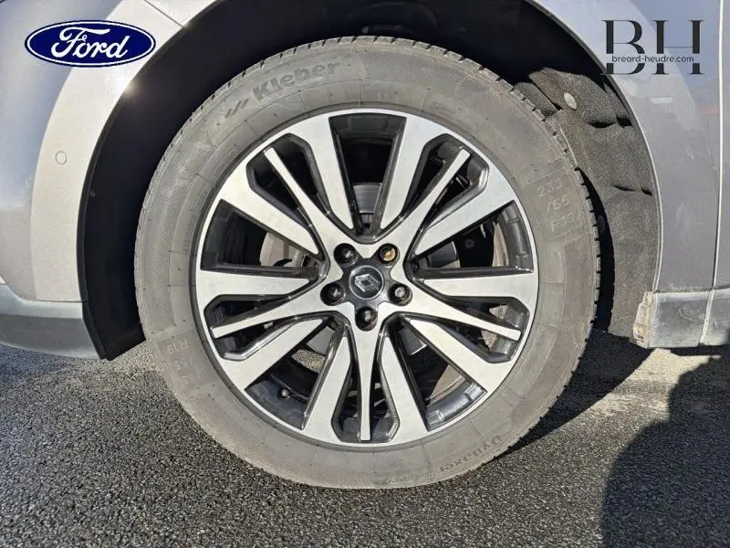 Gros plan sur la jante alu gris foncé et noir d'un Renault Espace gris Cassiopée, mettant en valeur le logo central Renault.