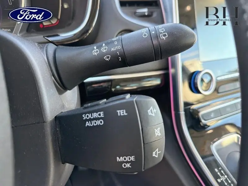 Gros plan sur les commandes au volant et la manette d'essuie-glace d'un Renault Espace gris, intérieur moderne avec écran tactile.