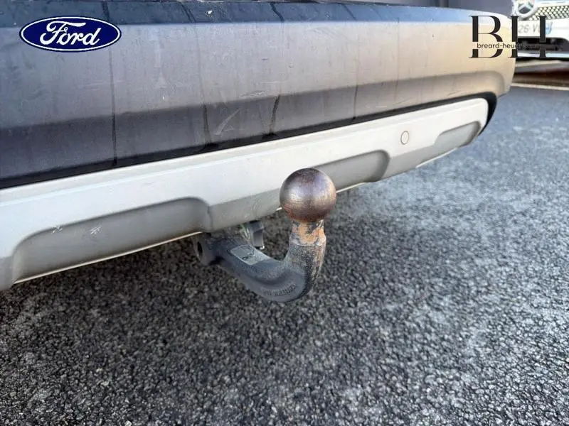 Gros plan sur l'attelage arrière rouillé d'un Renault Espace gris Cassiopée, vue centrée sur le pare-chocs inférieur.