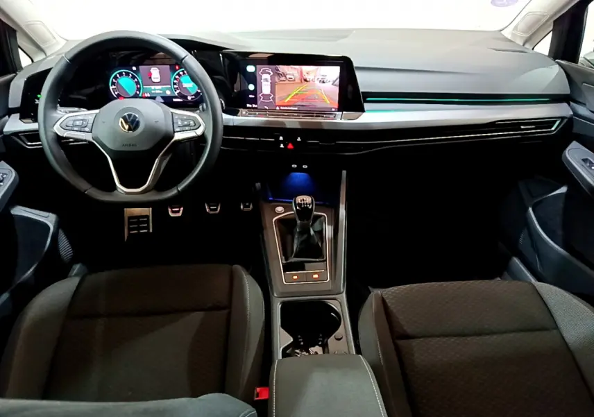 Intérieur avant de la Volkswagen Golf bleue 2022, vue du conducteur sur tableau de bord numérique et levier de vitesse manuel.