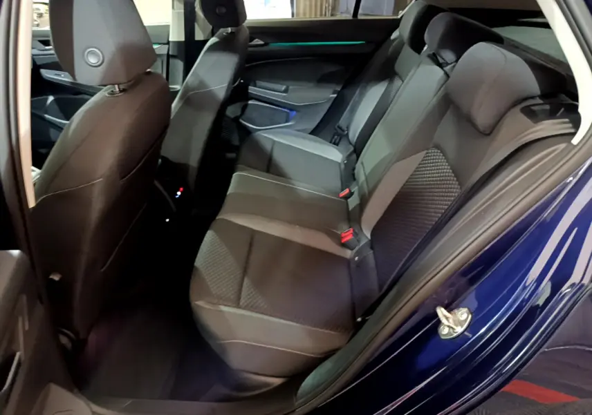 Vue côté gauche sur les sièges arrière gris foncé de la Volkswagen Golf 1.0 TSI Active bleu 2022 avec portes ouvertes.