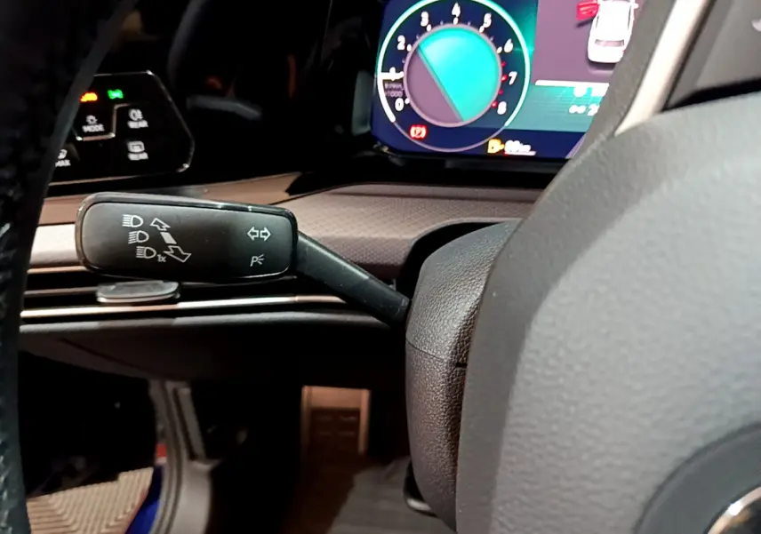 Gros plan sur la manette de clignotants et le tableau de bord numérique d'une Volkswagen Golf bleue 2022.
