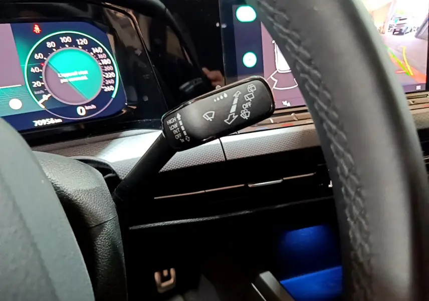 Gros plan sur la manette d'essuie-glace à gauche du volant cuir dans l'habitacle d'une Volkswagen Golf bleue 2022.