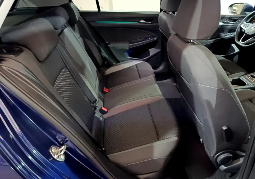 Vue intérieure côté gauche montrant la banquette arrière noire et la porte bleu métallisé d'une Volkswagen Golf 2022.