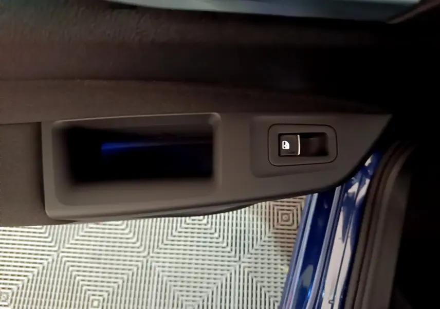Poignée intérieure de porte côté gauche d'une Volkswagen Golf 1.0 TSI bleu 2022, avec bouton de verrouillage.