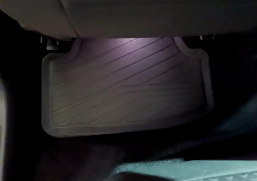 Tapis de sol noir côté conducteur de la Volkswagen Golf 1.0 TSI 2022, vue rapprochée sous le siège avant.