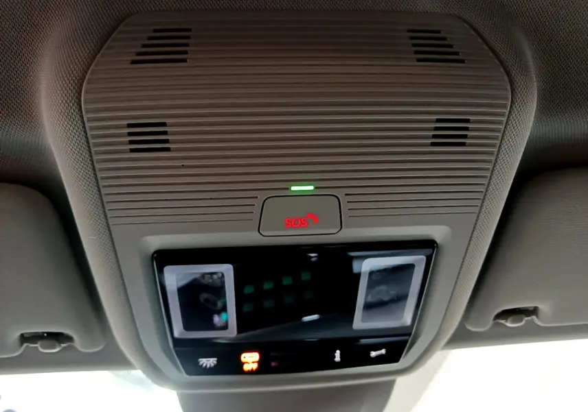 Vue en gros plan du plafonnier intérieur gris avec bouton SOS illuminé en rouge dans une Volkswagen Golf bleue