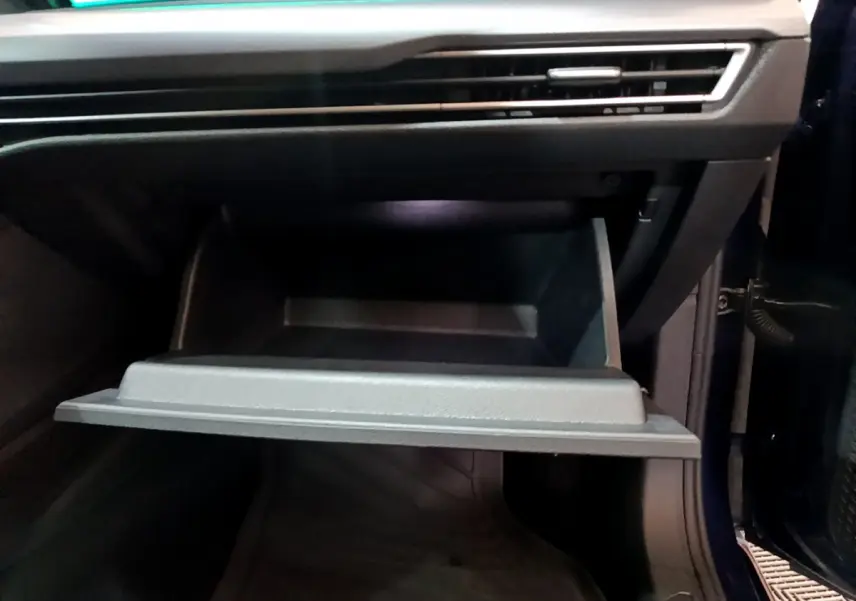 Gant de rangement ouvert côté passager dans l'habitacle d'une Volkswagen Golf bleu 2022.