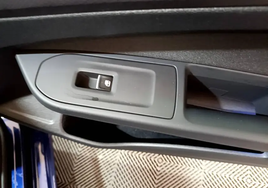 Gros plan sur la commande de verrouillage des portes côté conducteur d'une Volkswagen Golf bleu 2022.