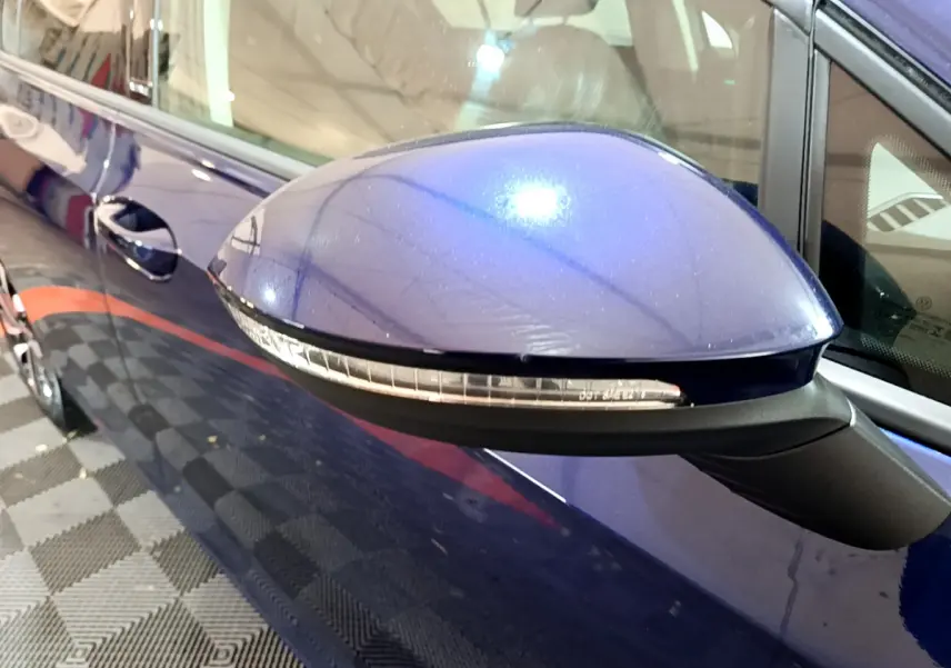 Rétroviseur côté gauche bleu brillant d'une Volkswagen Golf 1.0 TSI 2022 avec clignotant intégré.