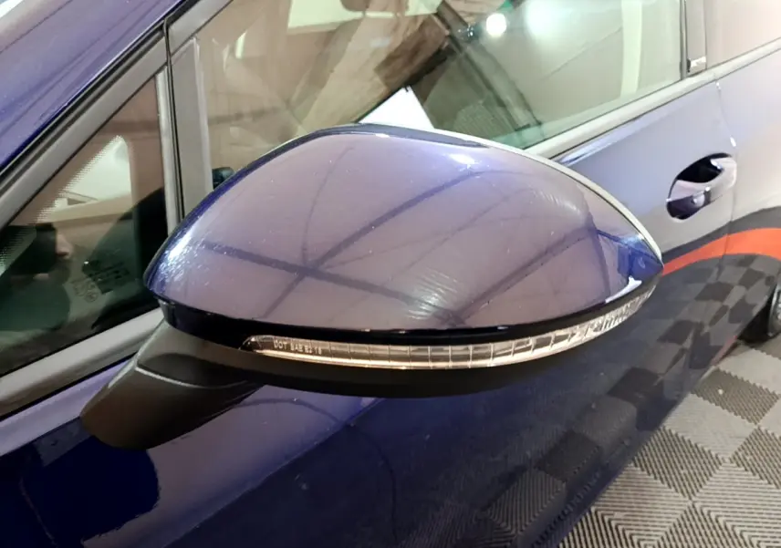 Rétroviseur côté gauche bleu de la Volkswagen Golf 1.0 TSI 2022 avec clignotant intégré, vue rapprochée.