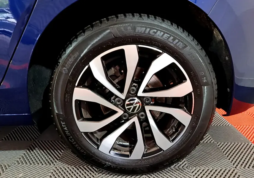 Gros plan sur la roue avant gauche de la Volkswagen Golf bleu, avec jante alliage bicolore et pneu Michelin.