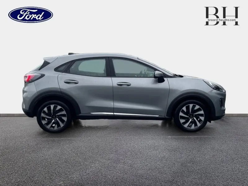 Vue de profil côté gauche d'un Ford Puma 2023 gris Solar métallisé avec jantes alliage distinctives.