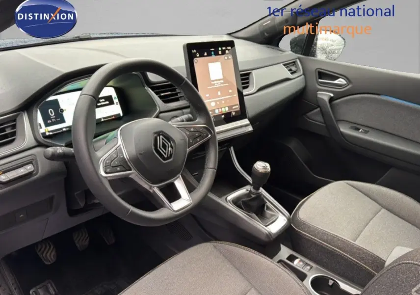 Vue intérieure côté conducteur du Renault Captur 2025, tableau de bord moderne avec écran tactile vertical et volant multifonction noir.