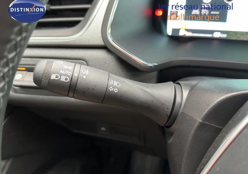 Gros plan sur la commande des feux à gauche du volant du Renault Captur bleu Iron Metal 2025, intérieur noir.