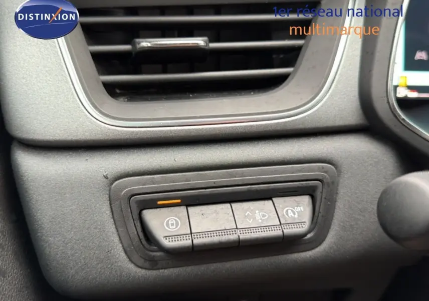 Détail des commandes de réglage des phares et verrouillage sur le tableau de bord du Renault Captur bleu Iron Metal 2025.