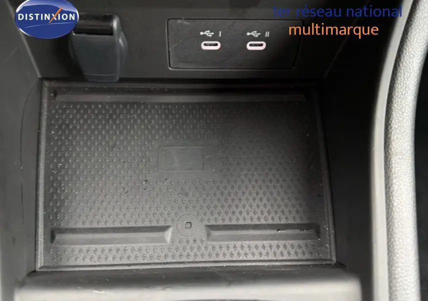 Gros plan intérieur sur la console centrale du Renault Captur 2025, montrant les ports USB et le tapis antidérapant noir.