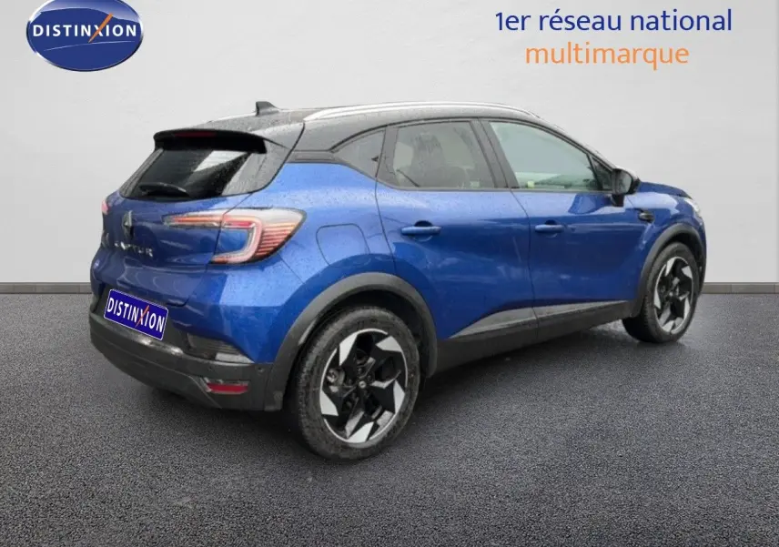 Vue 3/4 arrière droite d'un Renault Captur bleu Iron Metal avec toit noir et jantes bi-ton.