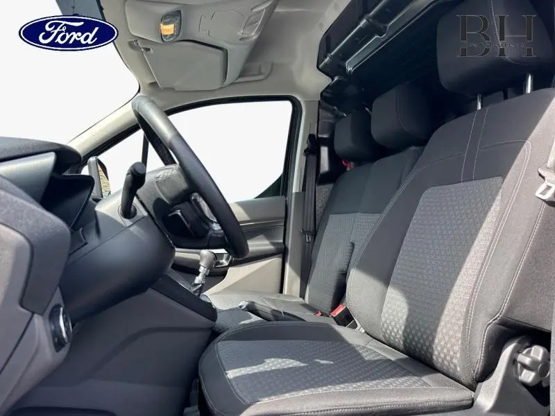 Vue intérieure côté conducteur du Ford Transit Connect L1 1.5 EcoBlue 2023, sièges tissu gris et volant multifonction.