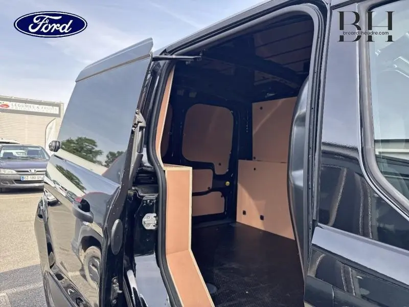 Vue arrière côté droit du Ford Transit Connect noir Agate Métallisée avec porte latérale ouverte montrant l’espace de chargement aménagé.