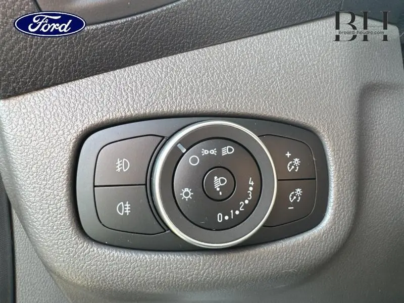 Gros plan sur la commande d'éclairage noire intégrée dans le tableau de bord gris du Ford Transit Connect L1 2023.