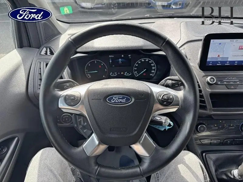 Vue intérieure centrée sur le volant multifonction noir du Ford Transit Connect 2023 avec tableau de bord et écran GPS visible.