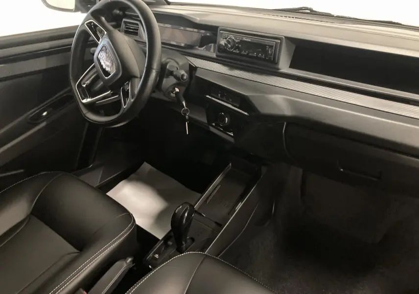 Vue intérieure côté conducteur du tableau de bord et console centrale noire du Ligier JS50 0.5 REVO D+ SELECT avec autoradio Pioneer.
