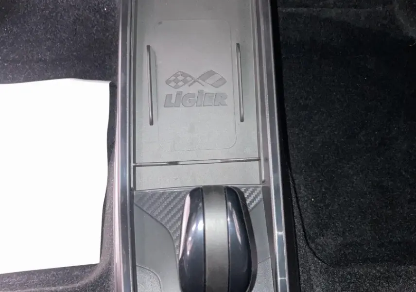 Vue plongeante sur la console centrale noire du Ligier JS50 0.5 REVO D+ avec levier de boîte auto et logo gravé.