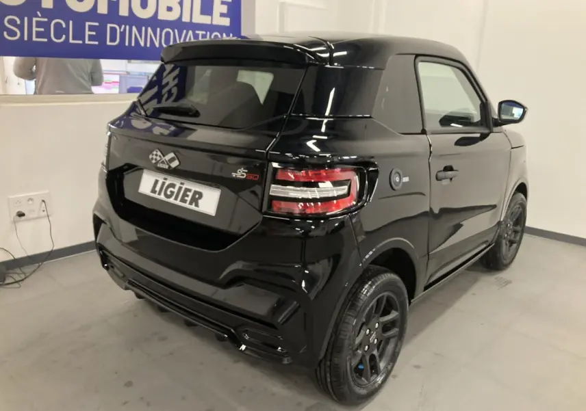 Vue 3/4 arrière droite d'une Ligier JS50 noire 2026 avec jantes alu noires et feux LED distinctifs.
