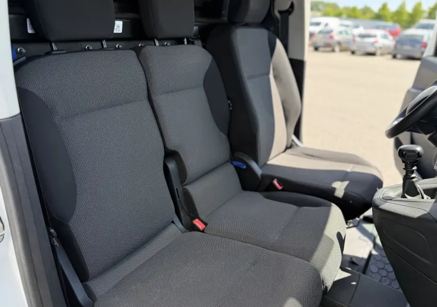 Vue intérieure côté gauche montrant les sièges avant gris foncé du Citroën Berlingo XL 2022 avec levier de vitesse manuel.