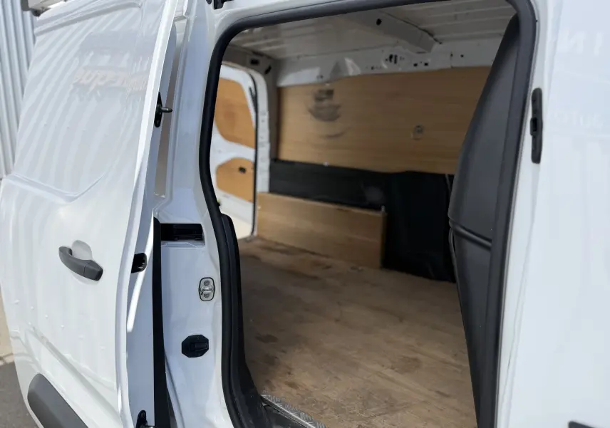 Vue intérieure côté droit du Citroën Berlingo XL blanc banquise avec porte coulissante ouverte et aménagement bois.