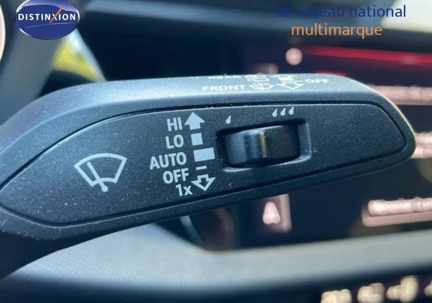 Gros plan sur la commande d'essuie-glace de l'Audi A3 Sportback noire 2025, intérieur visible en arrière-plan flou.