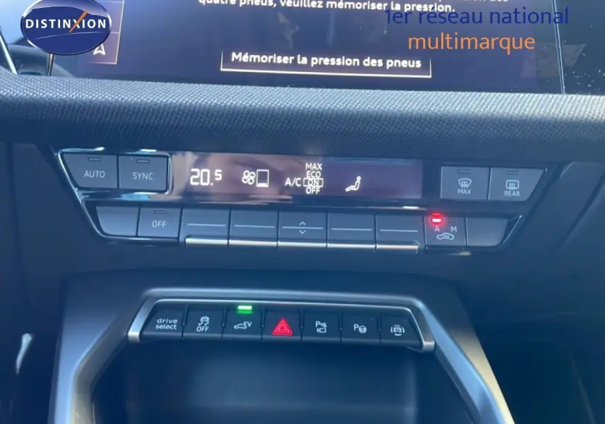 Vue rapprochée de la console centrale de l’Audi A3 Sportback noire 2025, montrant les commandes climatisation et fonctions hybrides.
