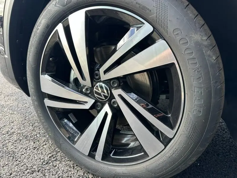 Gros plan sur la jante alliage noir et argentée du Volkswagen T-Roc 2025 avec pneu Goodyear visible sur sol asphalté.
