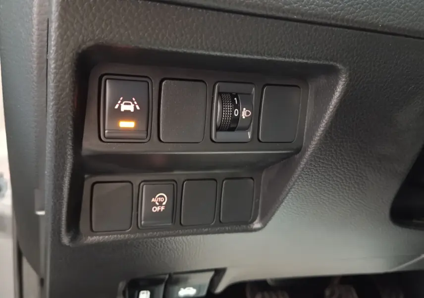 Gros plan sur les commandes d'assistance et réglage des phares du Nissan Qashqai gris clair, version 2019.