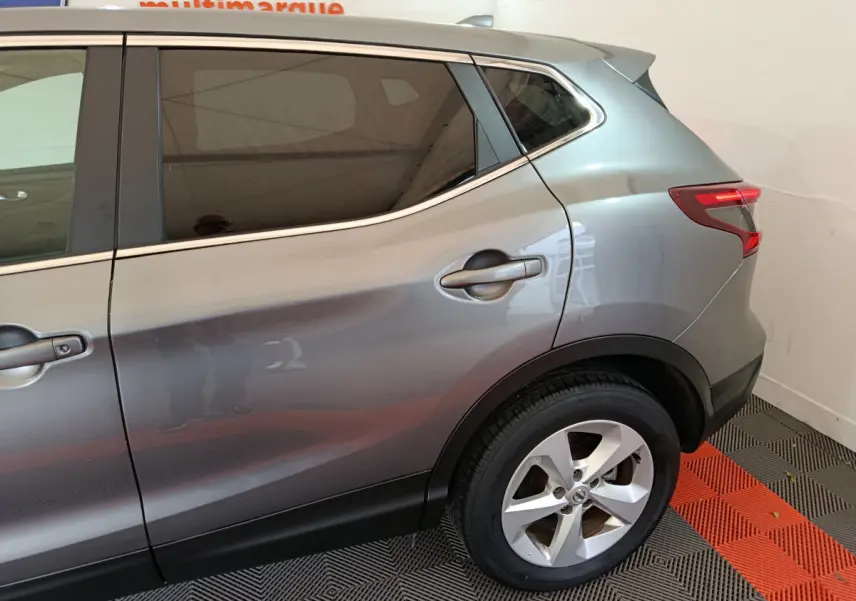 Vue côté droit arrière du Nissan Qashqai gris clair 2019 avec jante alliage et feux arrière LED distinctifs.