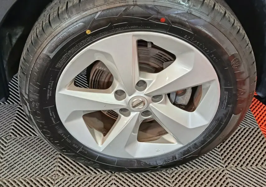 Gros plan sur la roue avant avec jante alliage argentée du Nissan Qashqai 2019 gris clair.