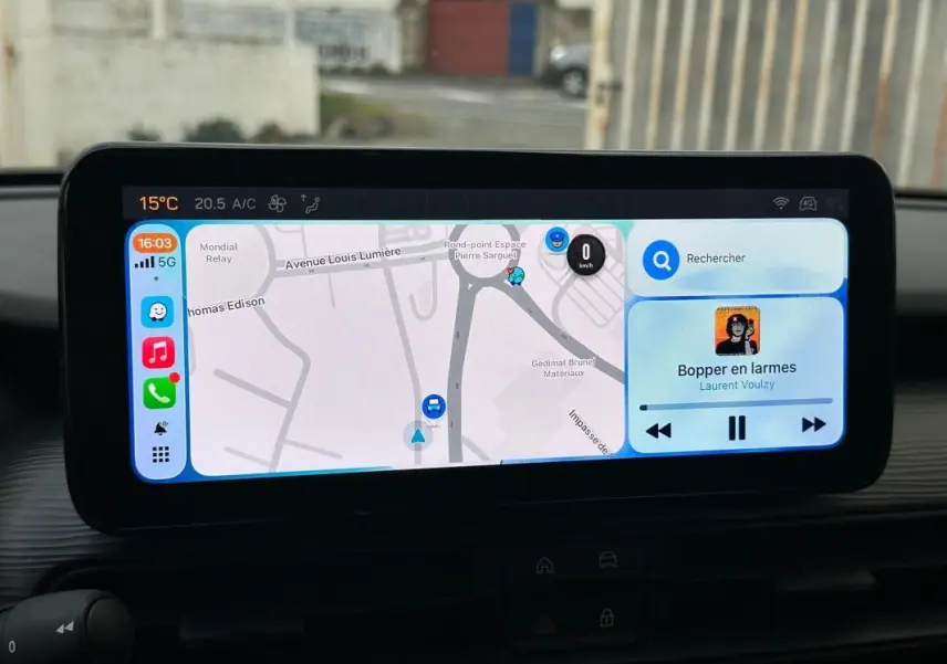 Écran tactile central du Jeep Avenger 2024 affichant la navigation et la musique, vue intérieure frontale.