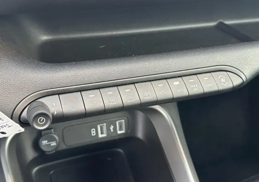 Gros plan sur la console centrale noire du Jeep Avenger 2024, montrant les commandes climatisation et prises USB.
