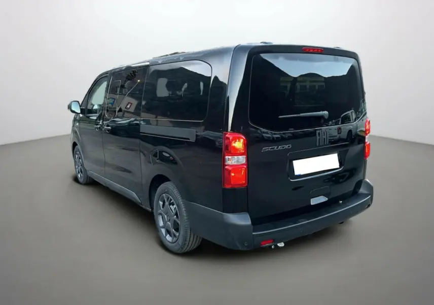 Vue 3/4 arrière droite du FIAT Scudo Fourgon noir avec vitres surteintées et feux arrière allumés.