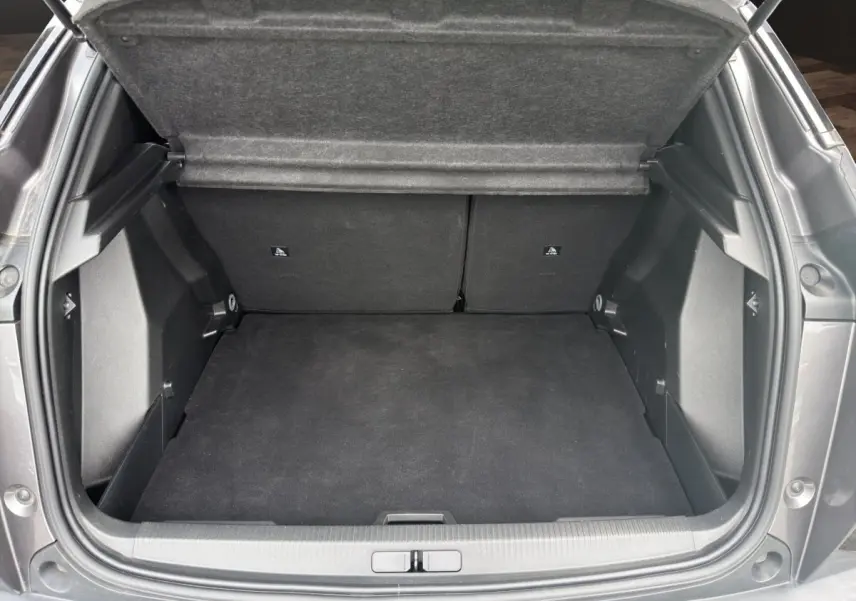 Coffre ouvert vu de l'arrière d'un Peugeot 2008 gris foncé, montrant un espace de chargement propre et spacieux.