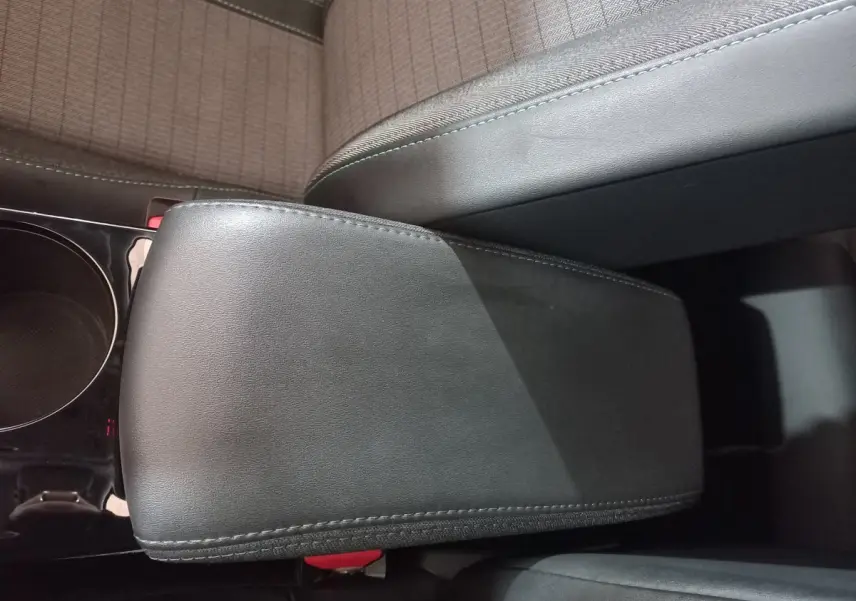 Accoudoir central noir en cuir dans l'habitacle du Peugeot 2008 Orange, vue plongeante sur les sièges avant.