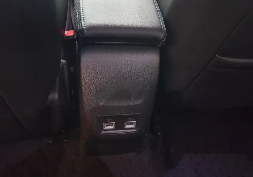 Prise USB double vue arrière entre les sièges noirs du Peugeot 2008 BlueHDi 110 S&S Allure Business 2021.