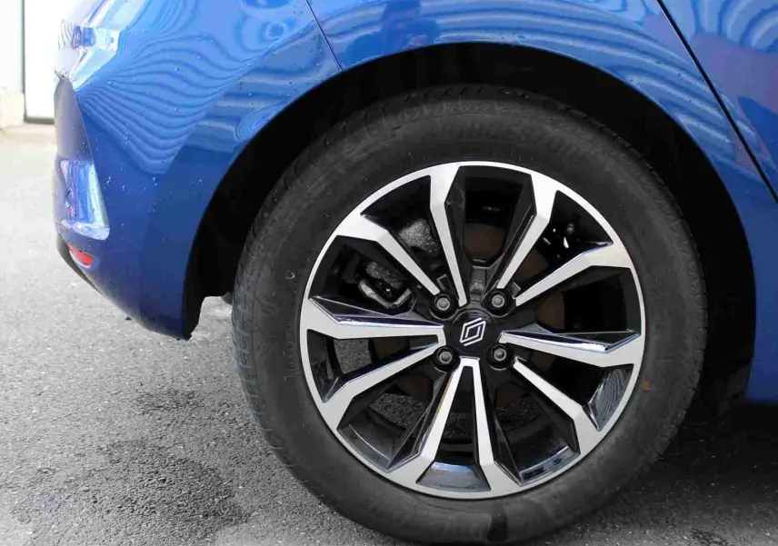 Gros plan sur la roue avant droite de la Renault Clio bleu iron metal avec jante alliage au design moderne.