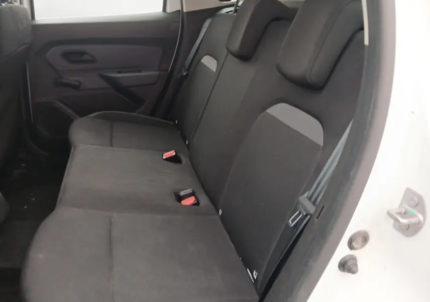 Vue intérieure côté arrière droit du Dacia Duster blanc 2021, montrant la banquette arrière en tissu noir avec appuie-têtes.