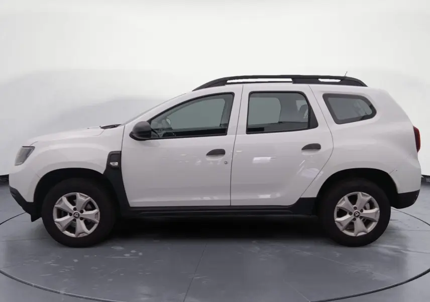 Vue latérale droite d'un Dacia Duster blanc 4x2 Eco-G 100 Essentiel avec barres de toit et jantes alliage.