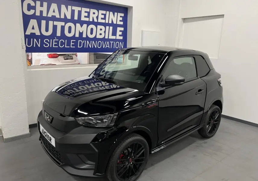 Vue 3/4 avant d'une Ligier JS50 noire mate avec jantes alu noires et badge Ultimate visible sur l'aile avant droite.