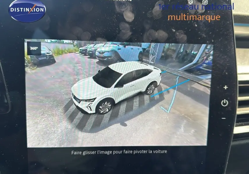 Vue 3/4 avant d'une Renault Rafale blanche 2024 affichée sur l'écran de contrôle avec indication de trajectoire de stationnement.